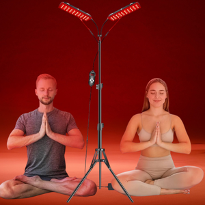 Two people meditating with a red light therapy lamp on a red background